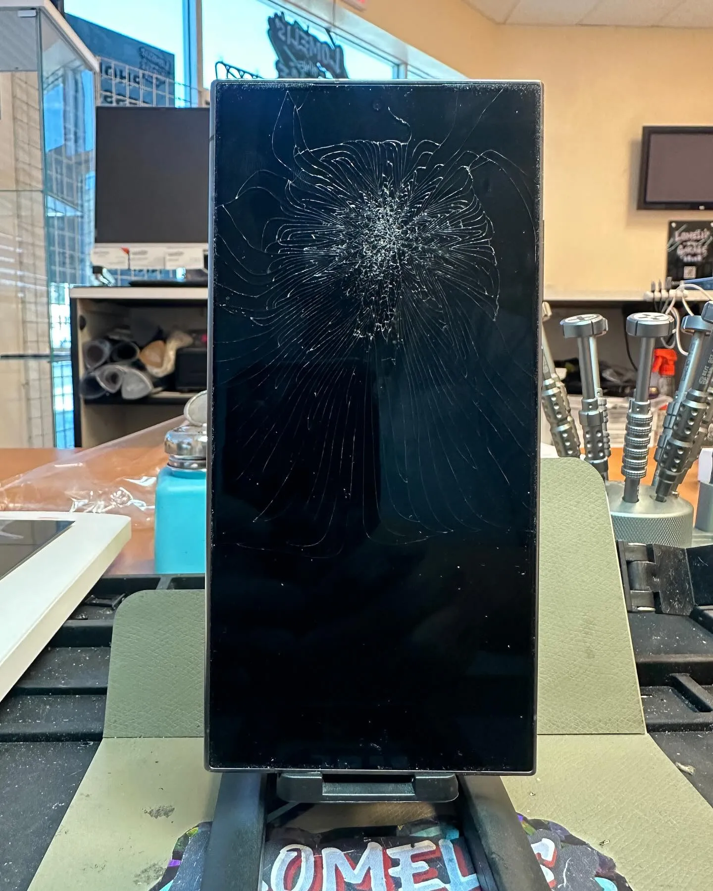 Samsung S24 Ultra with a heavily shattered screen before repair